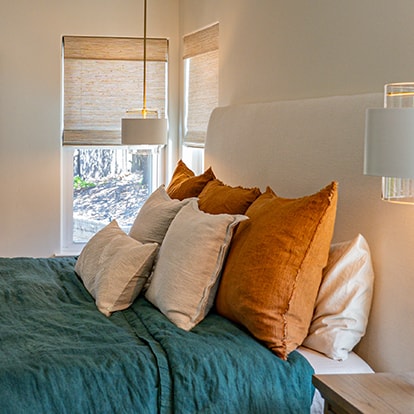 Layered cushions beside a window